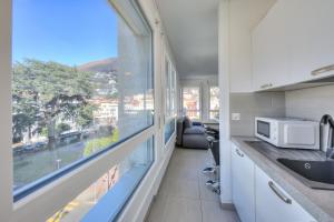 a kitchen with a large window and a microwave at Casa Cupido- Happy Rentals in Locarno