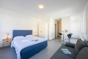 um quarto com uma cama azul e uma sala de estar em Casa Cupido- Happy Rentals em Locarno