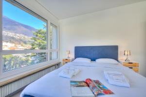 a bedroom with a bed with a large window at Casa Cupido- Happy Rentals in Locarno