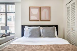 ワシントンにあるPenn Quarter Studio w Gym DM WD nr Metro WDC-577のベッドルーム1室(白いシーツとグレーの枕が備わるベッド1台付)