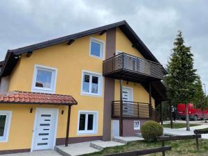 a yellow house with a balcony on top of it at Vila Kostic in Zlatibor