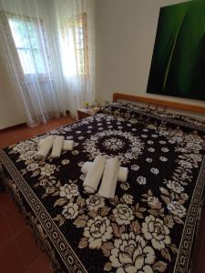 a bedroom with a bed with a black and white bedspread at La Casetta di Nerina - Agripark in Cansano