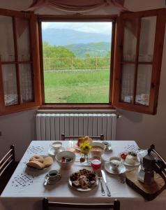 una mesa con platos de comida en ella con una ventana en La Casetta di Nerina - Agripark, en Cansano