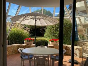- une table et des chaises avec un parasol sur la terrasse dans l'établissement Oceania, Appartement 2 étoiles à Carnac, à Carnac