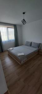 ein großes Bett in einem Zimmer mit Holzboden in der Unterkunft Vila Andrea in Oradea