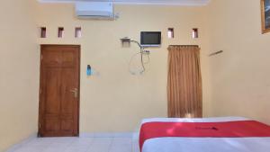 Timuran的住宿－RedDoorz Syariah At Endrayanti Inn RSUD Yogyakarta，一间设有床、门和电视的房间