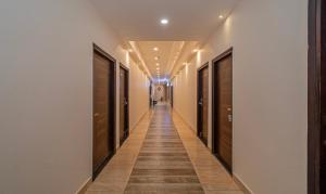 a hallway with a long corridor with wooden floors and ceilings at Itsy By Treebo - P Grand in Ludhiana