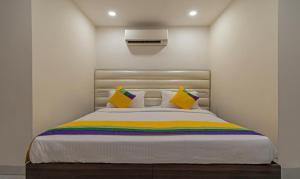 a bedroom with a bed with colorful pillows at Itsy By Treebo - P Grand in Ludhiana