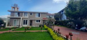 a house with a lawn in front of it at Velus Bungalow Ooty in Ooty