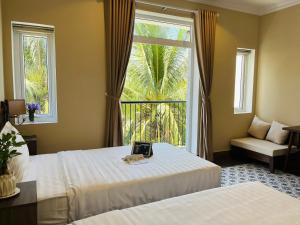 a hotel room with two beds and a window at Kemi House Hoi An in Hoi An +36 photos