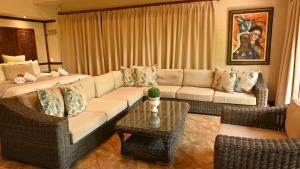 a living room with a couch and chairs and a table at LUXURY EN-SUITE ROOM WITH LOUNGE @ 4 STAR GUEST HOUSE in Middelburg