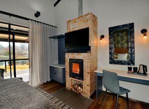 a bedroom with a fireplace and a desk with a television at Dunkeld East Hotel in Dullstroom