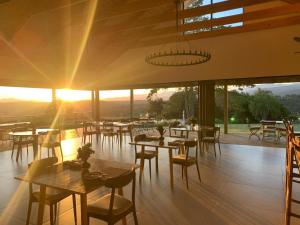 a restaurant with tables and chairs with the sunset in the background at Crags Country Lodge in The Crags