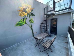 un tavolo e sedie con un dipinto di un fiore su un muro di Casa Mirasol Terrace Golden Horn Istanbul a Istanbul