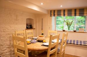 a dining room with a wooden table and chairs at Top Cottage, Oddington in Adlestrop