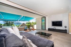 un soggiorno con divano e TV di Sea View Duplex per 5 in The Blue Point 88 Residence near Patong and Paradise Beach a Patong Beach