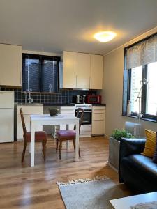 a living room with a table and a kitchen at Lugnt,centralt, parkering,altan. in Växjö