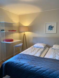 1 dormitorio con 2 camas y escritorio con lámpara en Lugnt,centralt, parkering,altan. en Växjö