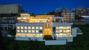 a large white building with lit up windows at night at Stone Island Pool Villa in Yeosu