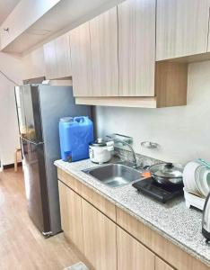 a kitchen with a sink and a refrigerator at Casa Concha by Celandine private residences in Manila