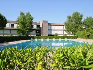un edificio de oficinas con piscina frente a un edificio en ISA-Residence with swimming-pool in Marina d Bibbona at only 300 m from the beach, en Marina di Bibbona