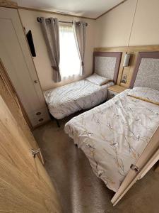 Katil atau katil-katil dalam bilik di Waterside mini lodge - pet friendly, WiFi, direct beach access & club on site - Meadow Lakes Caravan & Lodge Hire