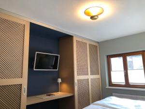 a bedroom with a bed and a tv on a wall at Haus Christina - Romantik Suite in Bürs