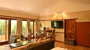 ein Wohnzimmer mit einem Sofa und einem Tisch in der Unterkunft LUXURY EN-SUITE ROOM WITH LOUNGE @ 4 STAR GUEST HOUSE in Middelburg