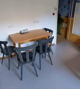 トラーベン・トラーバッハにあるMonkey Factory - Mini Home-Stay Hostelの木製テーブル(椅子4脚付)