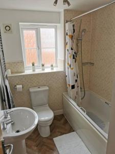 a bathroom with a sink and a toilet and a shower at Modern Roomy 3 BR Home Pershore in Pershore