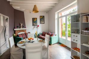 een eetkamer met een tafel en stoelen bij L'Écrin de Verdure - Pavillon avec piscine partagée in Thouars