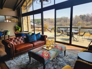 a living room with a leather couch and a table at Dunkeld East Hotel in Dullstroom