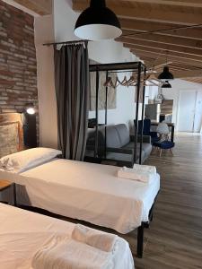a bedroom with two beds and a couch in a room at Borgovivobg il tuo rifugio in centro città in Bergamo
