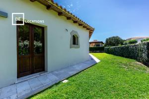 una puerta de una casa con un patio de césped en Molarina Bianca - Belocations en Monte Petrosu