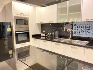 a kitchen with white cabinets and a sink at Wan D Villa Pattaya in Jomtien Beach