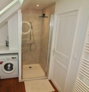 uma casa de banho com um chuveiro e uma porta branca em Location de Prestige : Duplex au Caractère Unique et Raffiné em Villefranche-sur-Saône