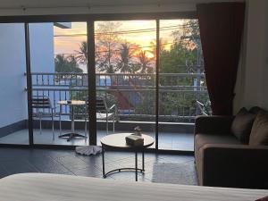 a living room with a couch and a view of a balcony at Deng's kamala beach Guesthouse in Kamala Beach