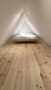 Łóżko w pokoju z drewnianą podłogą w obiekcie Kahnschifferhaus Mönkebude w mieście Mönkebude