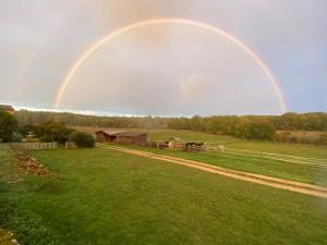 un arco iris en el cielo sobre un campo en Chambres d'hôtes de la Grande Combe, en Mauzac-et-Grand-Castang