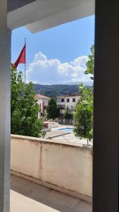 a view from a window of a building with a flag at City Center Apartment Vjosa River in Memaliaj