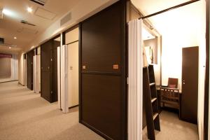 - un couloir avec des portes noires dans une chambre dans l'établissement HEARTS Capsule Hotel & Spa Nakasu -Male only-, à Fukuoka