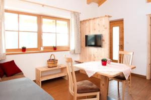 a room with a table and a bed and a tv at Laerchhof in Collalbo