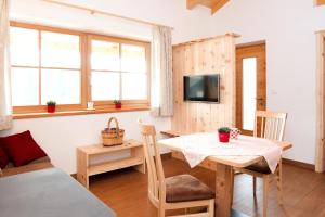 コッラルボにあるLaerchhofのテーブル、ベッド、テレビが備わる客室です。