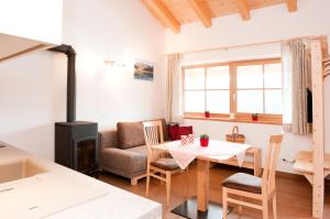 uma sala de estar com uma mesa e um fogão em Laerchhof em Collalbo
