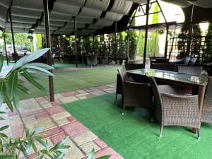 a patio with a table and chairs with green grass at Hotel Turist in Fălticeni