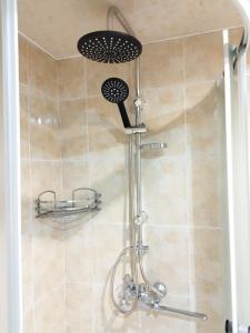 a shower with a shower head in a bathroom at Country House Uliana in Tskaltubo