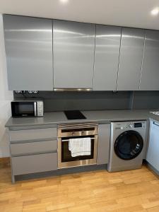 a kitchen with a washing machine and a microwave at Loft_Luminoso_Efeso in Madrid