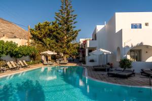 a swimming pool with chairs and a building at Hippocampus Hotel in Kamari