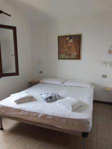a white bed with two towels on top of it at Panoramicissima in Costa Rei