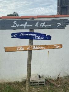 um sinal de rua de madeira em frente a um edifício em Face à la plage em Bourcefranc